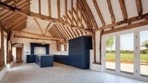 Open kitchen with exposed beams and navy cabinets